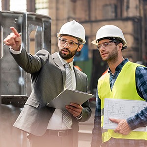 Amtivo (Formerly Certification Europe and EQA) - ISO 45001 Free Introduction Course - Two workers in hardhats, one in a suit explaining something to the other