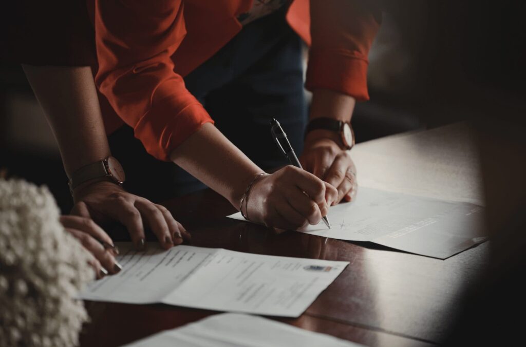 multisite certification - person signing papers at a table