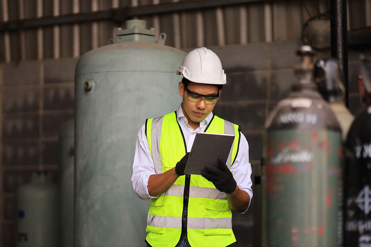 ODS and F-gas inspection campaign - man reading clipboard with tanks in background