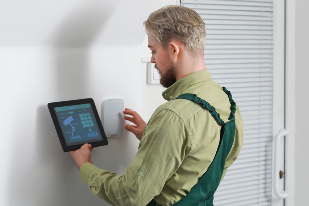 Amtivo (Formerly Certification Europe and EQA) - Worker installing an Access Control System using a touchscreen device